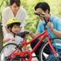 10月から自転車保険の加入義務化に向け、親子で自転車の安全点検を行っている場面。正しい乗り方を学ぶ大切さを伝える。