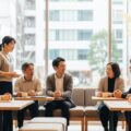 神戸市が令和8年度国民健康保険料率を決定する様子を示した画像。住民が集まり、地域の健康保険について議論している情景。