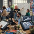 アニメ制作者向け労災保険の特別加入窓口が新設。現代のアニメ制作現場で働くクリエイターたちの姿を描いたワークスペースの様子。