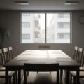 介護保険「２割負担拡大」が５度目見送りへ。会議室の空間が政策議論の不確実性を伝えています。