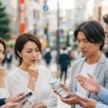 国民健康保険料が高くなる理由と保険料を安くするための対策について話し合っている現代日本の人々の姿。