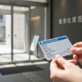「2025年12月で旧保険証失効！」マイナ保険証への完全移行と資格確認書の継続発行についての情報を感じさせる医療現場のシーン。