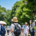 LINEやPayPayから加入可能な熱中症リスクに備える1日単位の保険について、都市での夏の活動中に人々が熱中症対策をしている様子を示す静かな風景。