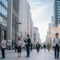 骨太の方針で現役世代の社会保険料率引き下げを目指す政策を反映した、現代日本の都市の日常風景。
