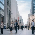 骨太の方針で現役世代の社会保険料率引き下げを目指す政策を反映した、現代日本の都市の日常風景。