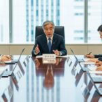 マイナンバーカード義務化を見送り、政府が示した理解促進と利便性向上の戦略についての議論が行われている現代日本のオフィスシーン。