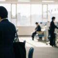 マイナカード更新に伴う旧カード回収と保険証・免許証機能の継続利用を示す日本の行政窓口のシーン。