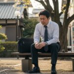 65歳定年退職者が高年齢求職者給付金受給のため、1か月前に辞めることの背景を考える情景。
