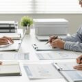 68歳在職老齢年金受給者の厚生年金保険料について、働くシニアと書類があるオフィスの情景を描写。