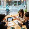 円安で海外旅行保険料が上昇する状況を描いた現代の日本のカフェの風景。人々が旅行保険について議論する様子を捉えています。
