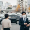 自動車保険の8週間ルールが来月施行に伴う都市の日常風景。軽い接触事故の様子を抽象的に表現.