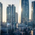 「250万件漏えい」大手損保４社ショックを象徴する都市の風景。個人情報漏えいの影響を感じさせる抽象的な要素が含まれています。