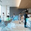 8月から健康保険証が完全廃止され、新しいマイナ保険証と資格確認書が必要になります。病院での混雑した受付の様子を示しています。
