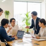 2026年の社会保険料、106万円・130万円の壁に関するダブル改正の動向を示す現代の職場風景。多様な人々が議論しているシーン。
